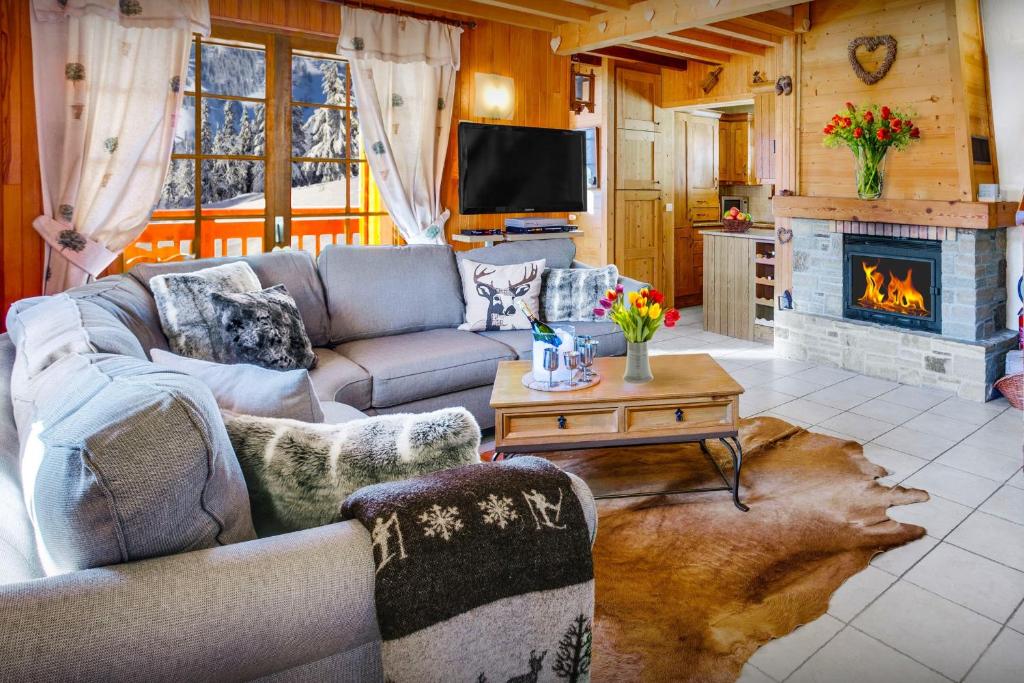 a living room with a couch and a fireplace at Chalet Chenavray - OVO Network in Manigod