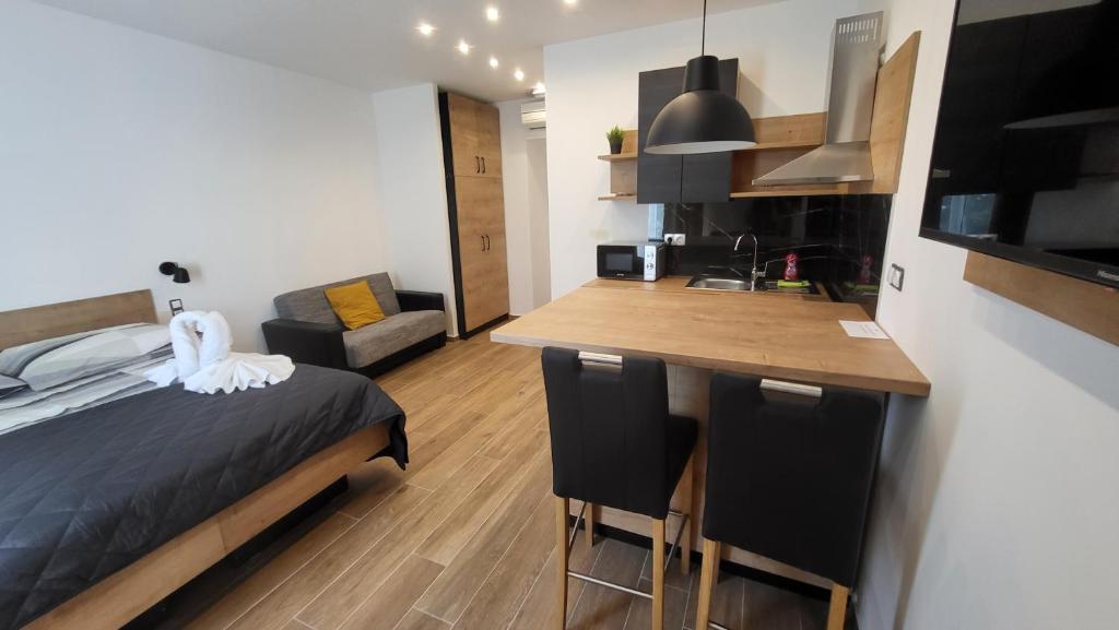 a bedroom with a bed and a kitchen with a counter at Imperial Central Residences West in Rijeka