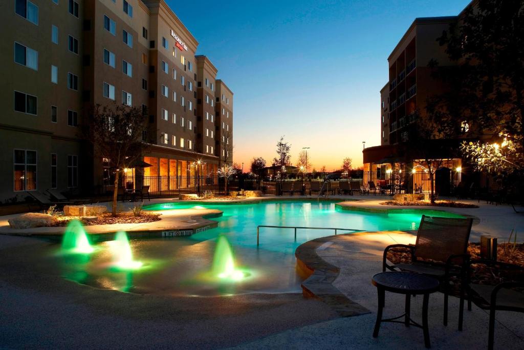 a swimming pool with green lights in a building at Residence Inn by Marriott San Antonio Six Flags at The RIM in San Antonio