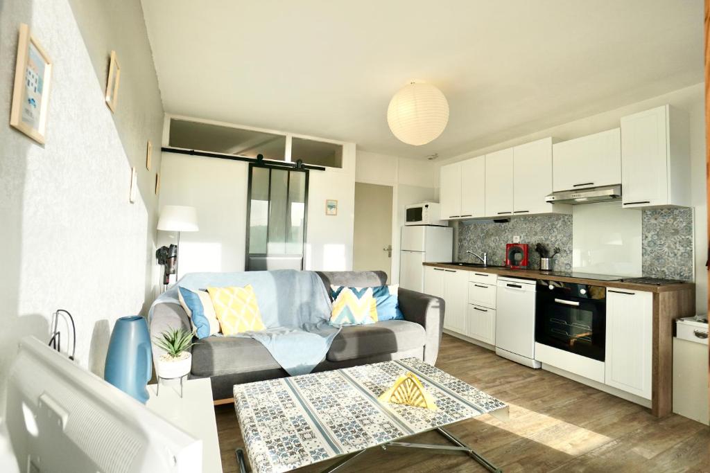 Il comprend un salon avec un canapé et une cuisine. dans l'établissement Heol * plage à 100m*, à Larmor-Plage