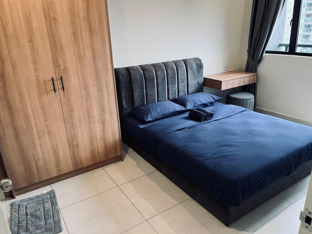 Schlafzimmer mit einem Bett mit blauer Decke in der Unterkunft Majestic maxim 3 bedrooms link MRT cheras Kuala lumpur in Cheras