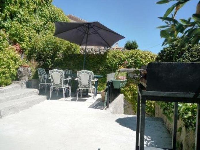 un tavolo e sedie con ombrellone su un patio di Casa Abilio a Villatoro