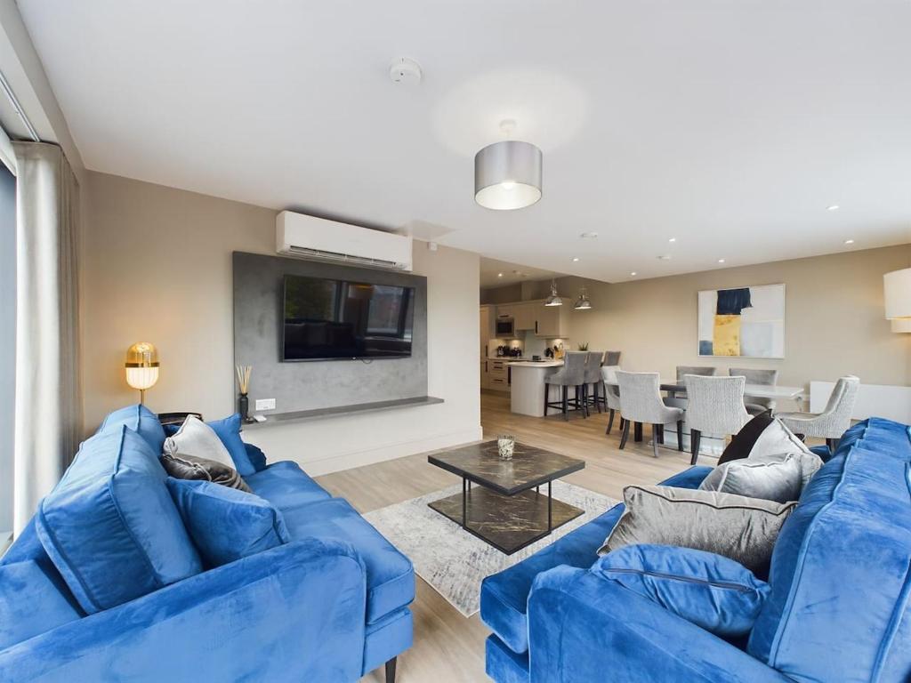 uma sala de estar com dois sofás azuis e uma mesa em Adelaide Apartment on Lisburn Road by Lesley em Belfast
