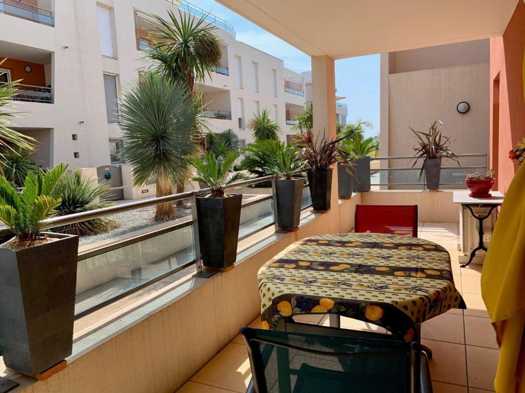 d'un balcon avec une table et des plantes en pot. dans l'établissement Splendide T3 avec Terrasse et Box Privé à 2 Pas de l'Étang de Thau - FR-1-604-41, à Mèze