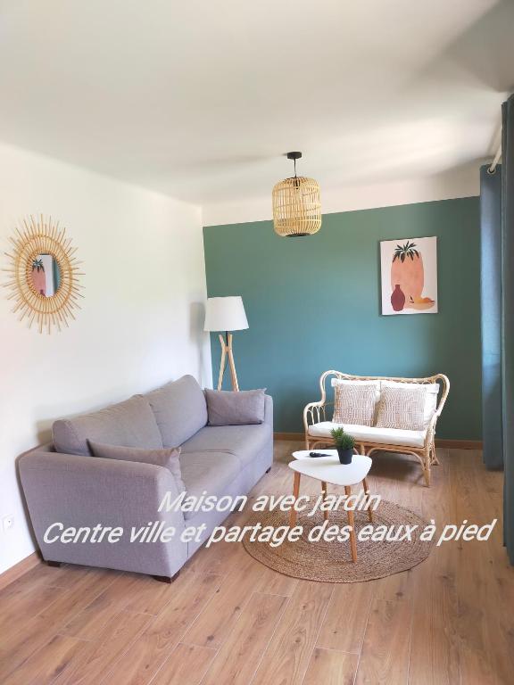 un salon avec un canapé et une table dans l'établissement Gîte Les Demoiselles des Sorgues, à LʼIsle-sur-la-Sorgue