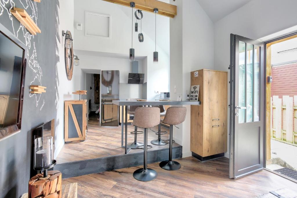 une cuisine et un salon avec une table et des chaises dans l'établissement Cosy Lodge - Charmant lodge en plein cœur de Dinan, à Dinan