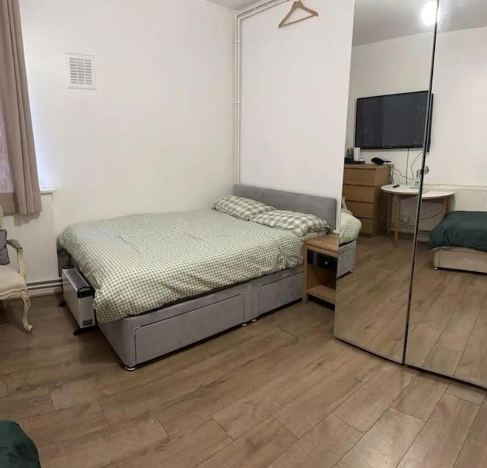 1 dormitorio con 1 cama y TV de pantalla plana en Small Studio apartment - quick access to all of london en Londres