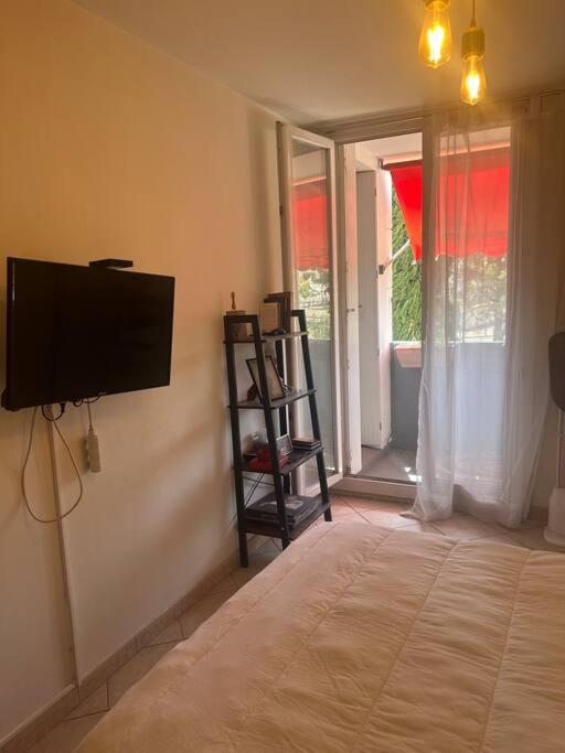 a bedroom with a flat screen tv on the wall at Logement spacieux idéal famille in Marseille