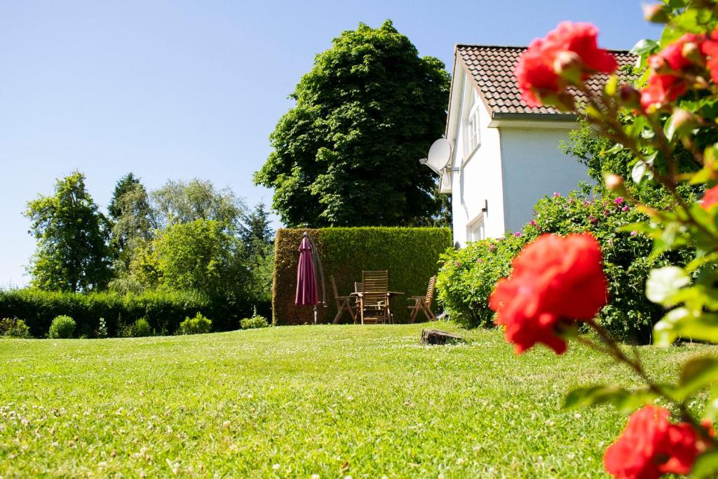 een tuin met een huis en een tafel en paraplu bij Ferienwohnung Brunkhorst in Krakvitz in Putbus