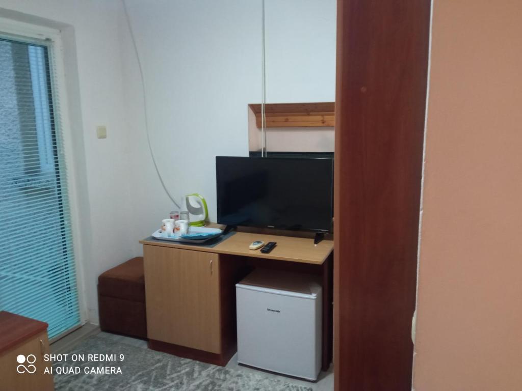 um quarto com uma secretária e uma televisão de ecrã plano em Summer SZ Guest House em Sozopol