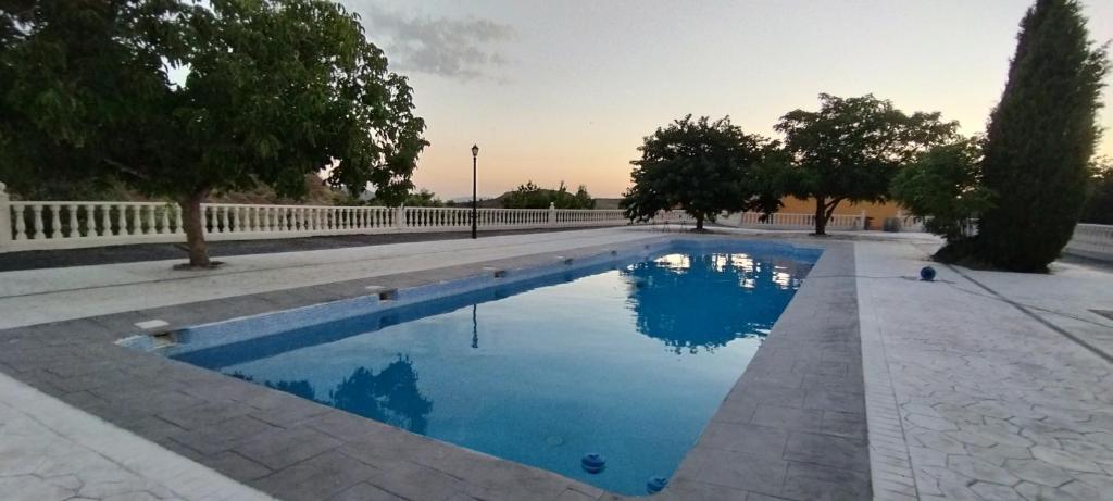 una piscina de agua azul en un parque en Finca Cortés, en Alcaraz