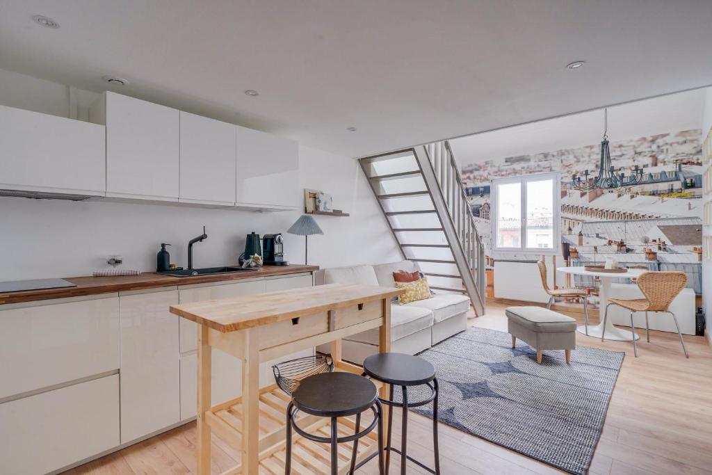 une cuisine et un salon avec une table et des chaises dans l'établissement Les Toits - Location Moyenne Durée - Centre, à Bordeaux