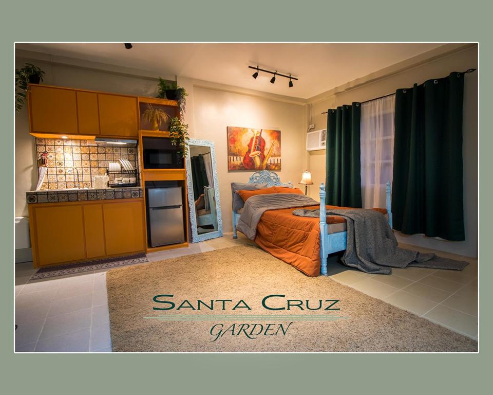a bedroom with a bed and a kitchen at Santa Cruz Garden in Tacloban
