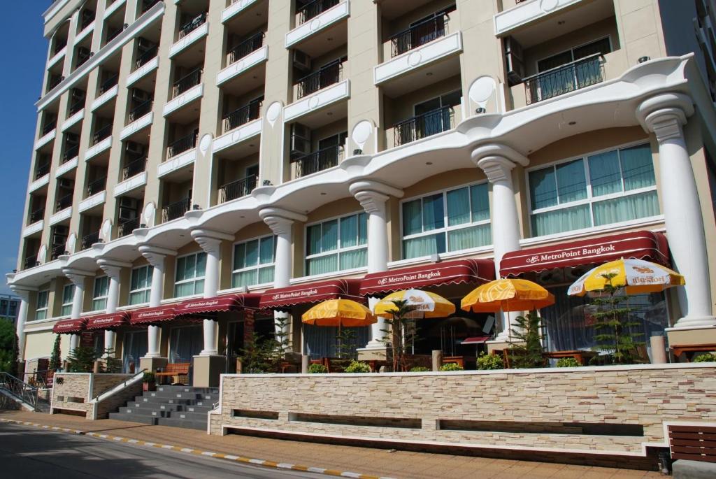 a large building with umbrellas in front of it at Metro Point Bangkok in Bangkok