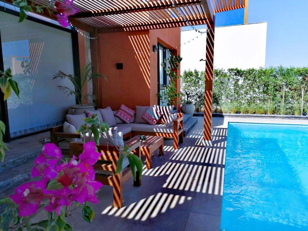 un patio con sofá y piscina en Luxury Villa With a Pool in Soma Bay, en Hurghada