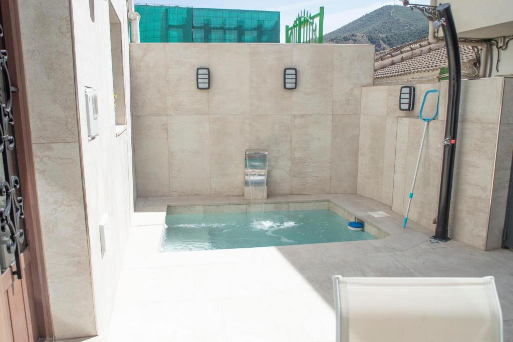 una pequeña piscina de agua en medio de un edificio en La Cueva de la Abuela, en Cenes de la Vega