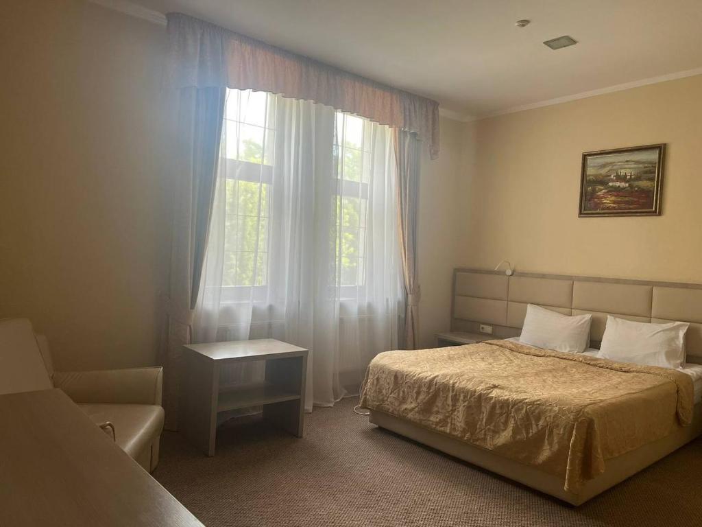 een slaapkamer met een bed en een raam bij Ligena Hotel in Boryspilʼ