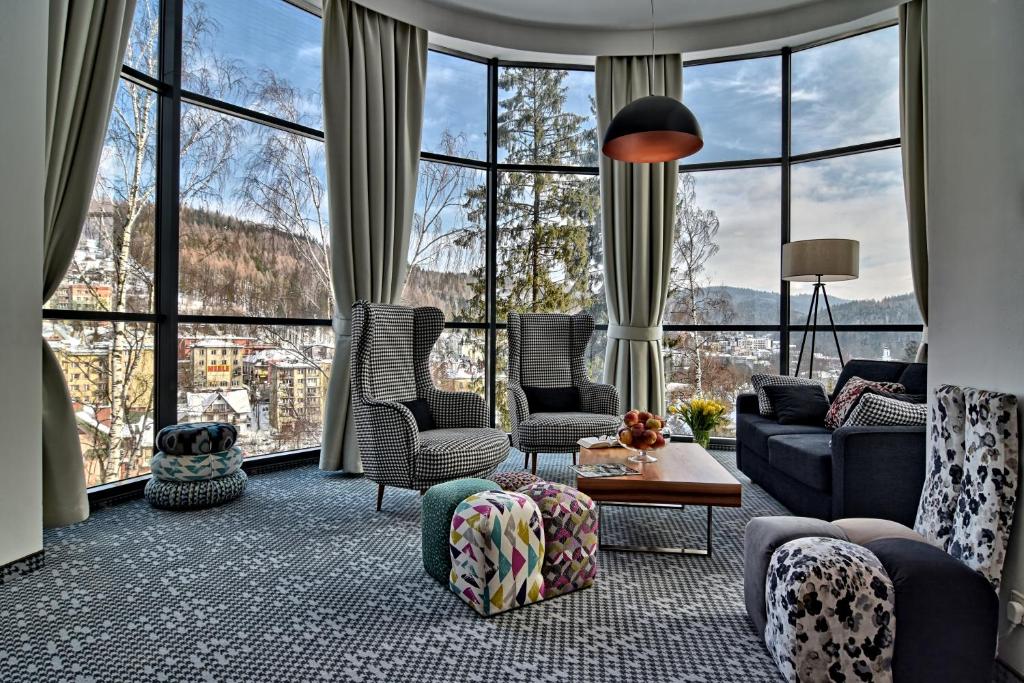 a living room filled with furniture and large windows at Hotel Krynica Conference & SPA in Krynica Zdrój