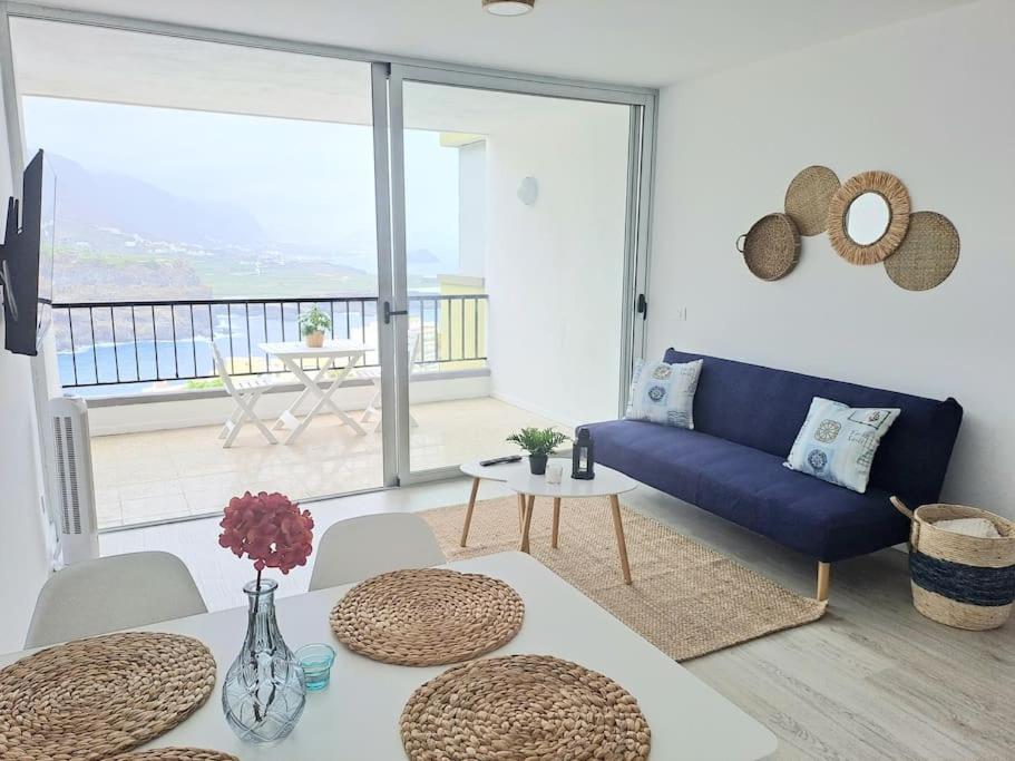 a living room with a blue couch and a table at Apartamento en Playa San Marcos in Icod de los Vinos