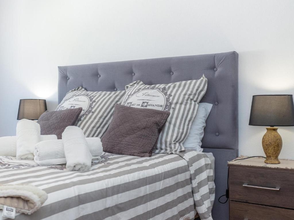 una camera da letto con letto e lenzuola a righe e cuscini di Figueira Casino Center Apartment a Figueira da Foz