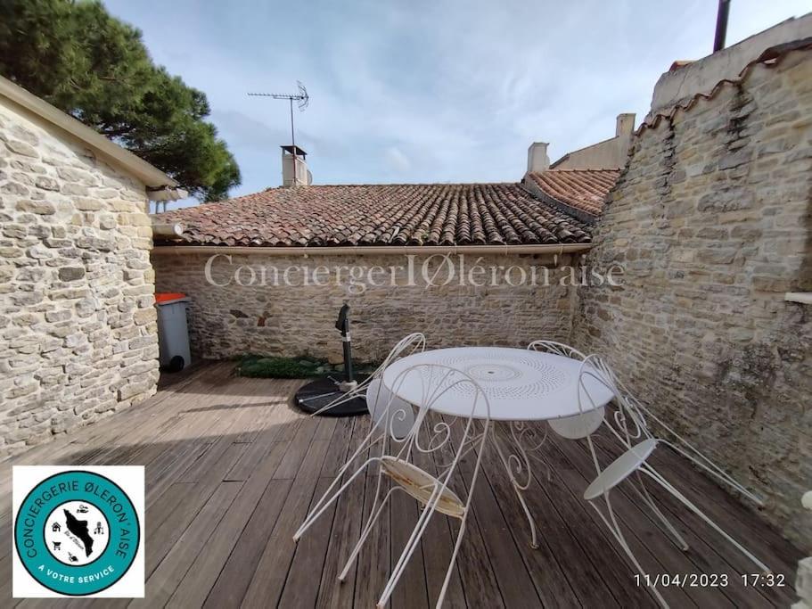 a table and chairs sitting on a wooden deck at Maison de la Sau in La Nouette