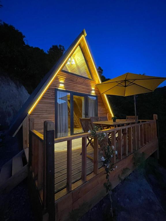 Cette petite cabine dispose d'une terrasse avec un parasol. dans l'établissement CİVRA BUNGALOV, à Sürmene