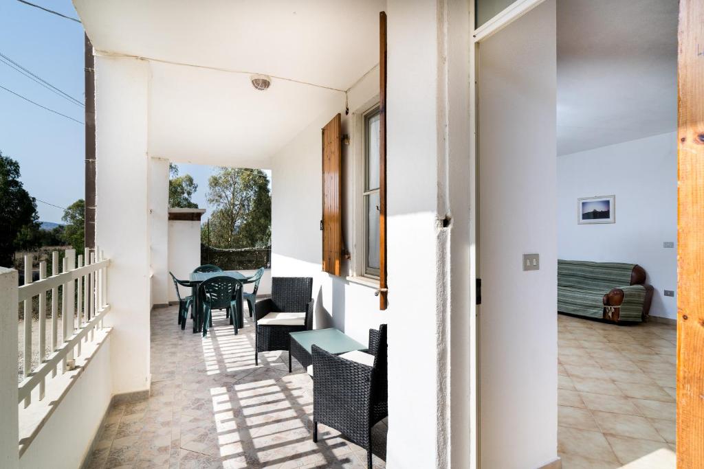 einen Balkon mit Stühlen und Tischen auf einem Haus in der Unterkunft Casa con veranda in Posada