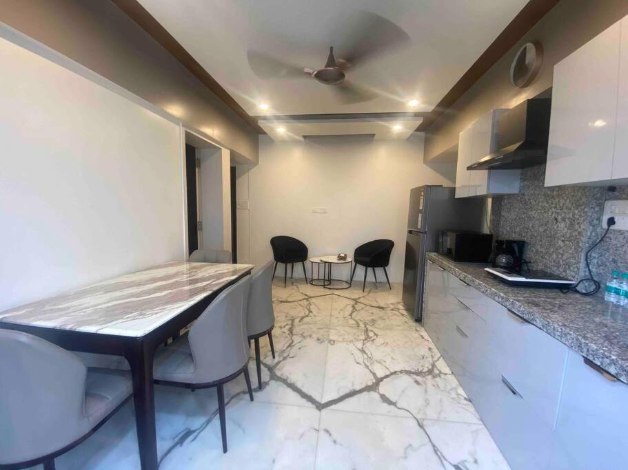 a kitchen with a table and chairs in a room at Bandra’s Prime luxurious 2 BHK in Mumbai