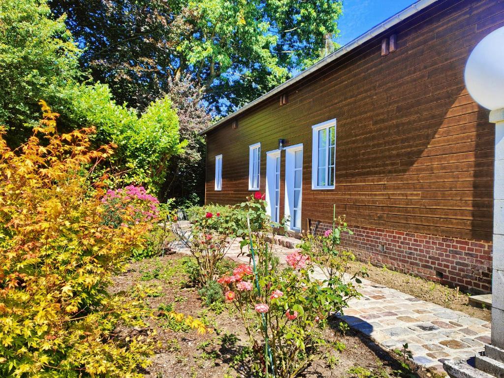 a garden in front of a building with flowers at La maison du bien-être 