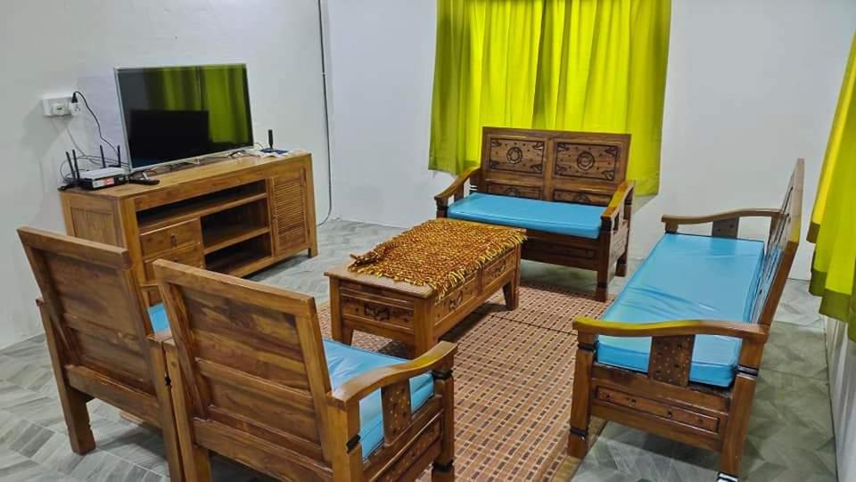 een woonkamer met 3 stoelen en een televisie bij Raniah Homestay2 in Kuching