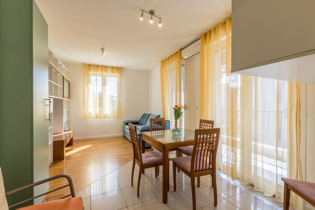 a dining room and living room with a table and chairs at Hana City Apartment in Split