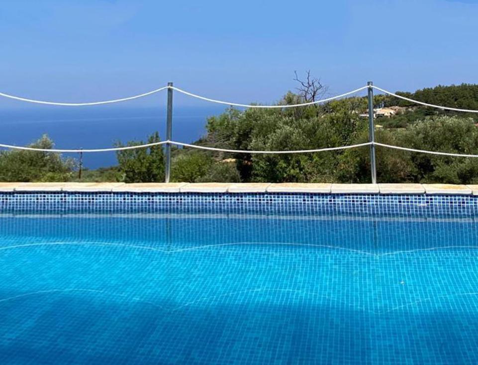 a large swimming pool with a volleyball net at Villa Marina in Kalamitsi