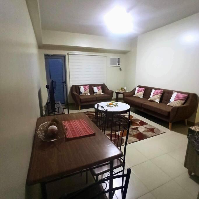 ein Wohnzimmer mit einem Tisch und einem Sofa in der Unterkunft Spacious 2BR in Araneta Center Cubao Pet Friendly in Manila