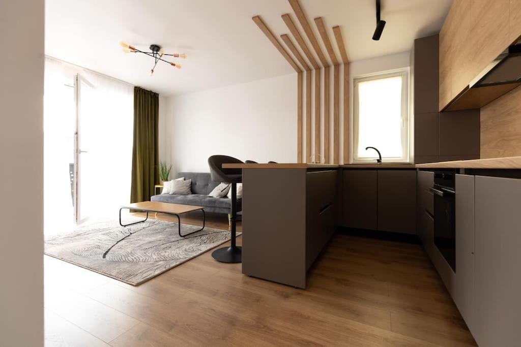 uma cozinha e sala de estar com uma mesa e um sofá em Emerald Apartment em Baia Mare