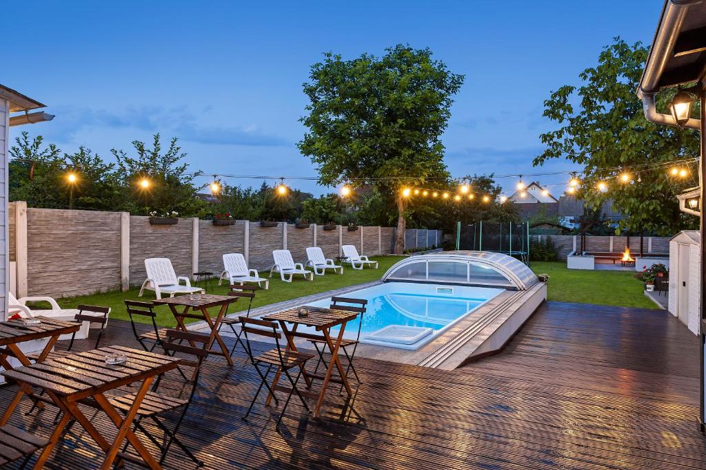 a backyard with a pool and tables and chairs at Pensiunea Alina "Adults Only" in Sibiu