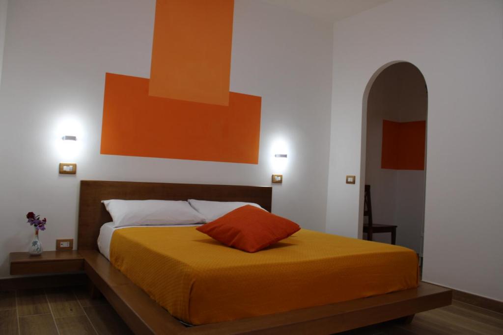 1 dormitorio con 1 cama con manta naranja en Zia Bianca BeB, en Vietri