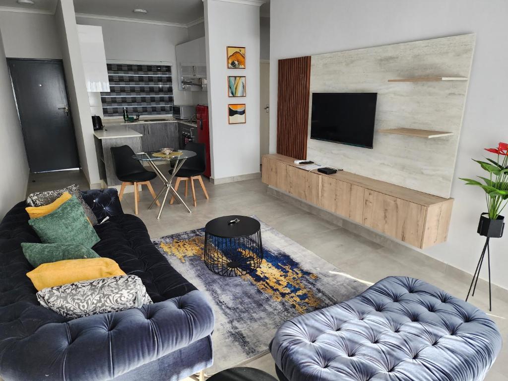 a living room with a couch and a television at SaronaC102 in Gaborone