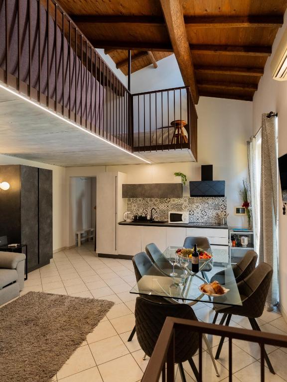 a kitchen and living room with a glass table and chairs at I Fragoli al David Apartments Florence in Florence