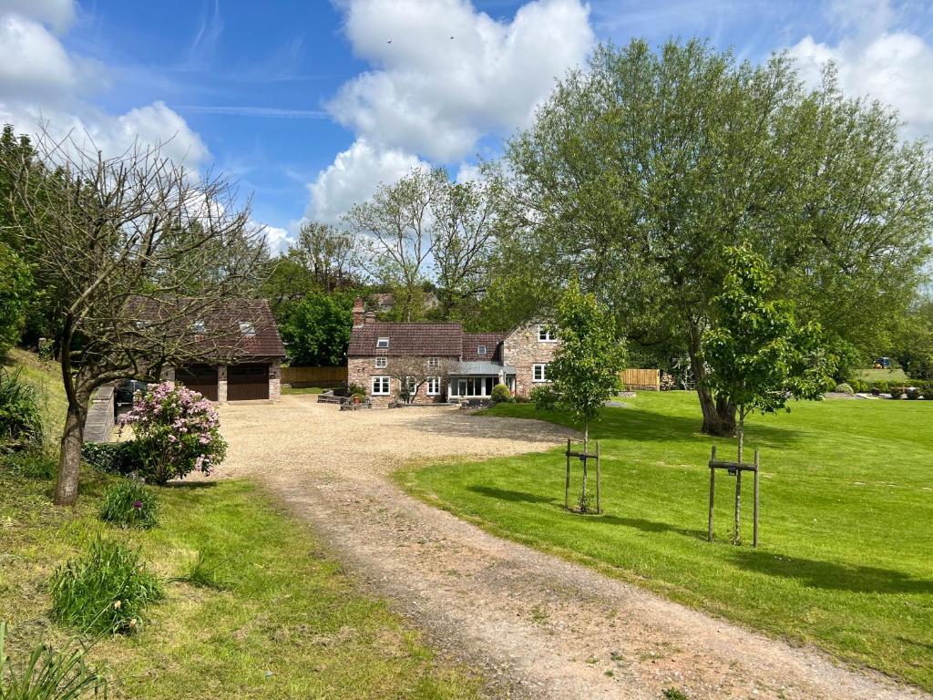 un chemin de terre menant à une maison avec des arbres et de l'herbe dans l'établissement Studio Apartment, à Wells