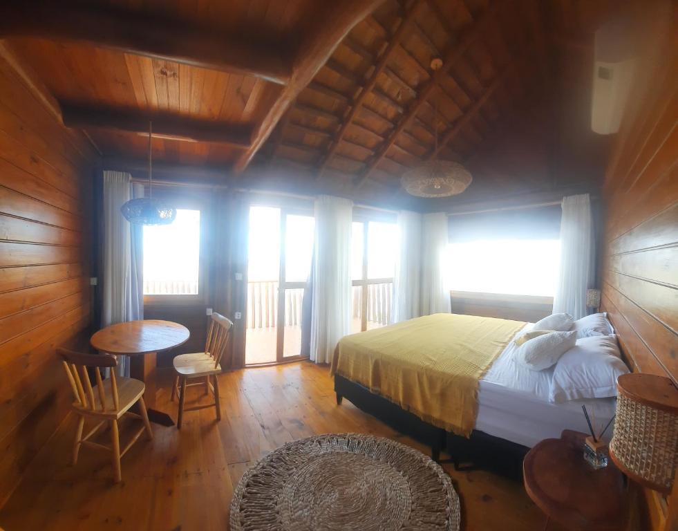 a bedroom with a bed and a table and chairs at Vilaria Tatajuba in Tatajuba