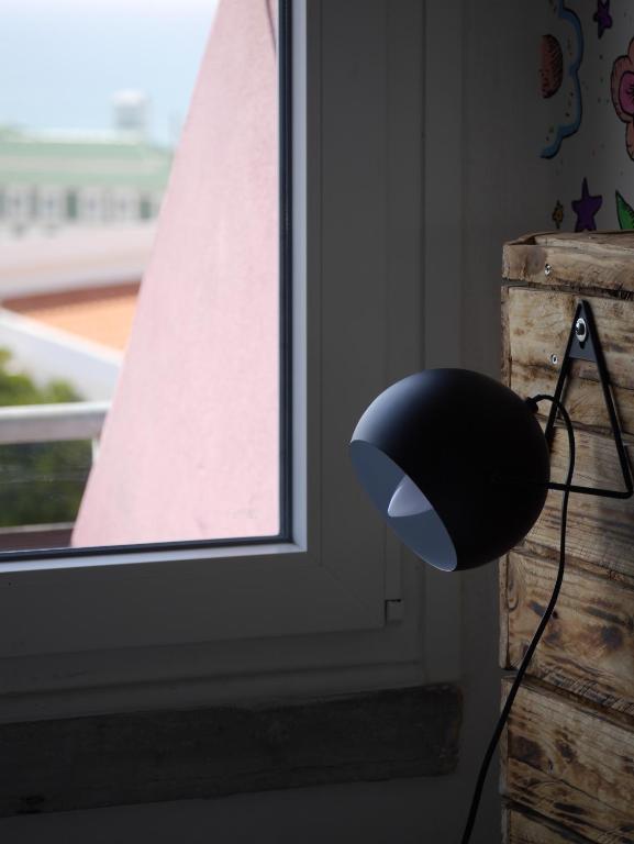 a black lamp sitting next to a window at Hostel & Surfcamp 55 in Ericeira