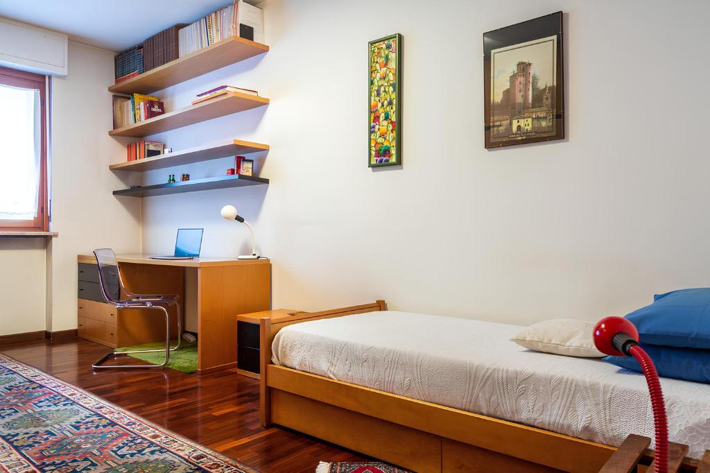 een slaapkamer met een bed en een bureau met een computer bij i cedri in Turijn