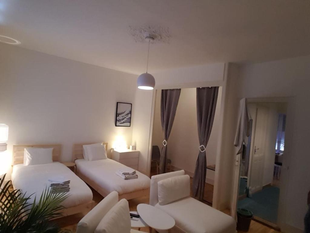 um quarto com 2 camas, um sofá e uma cadeira em DIAMOND appartement au centre de Genève em Genebra