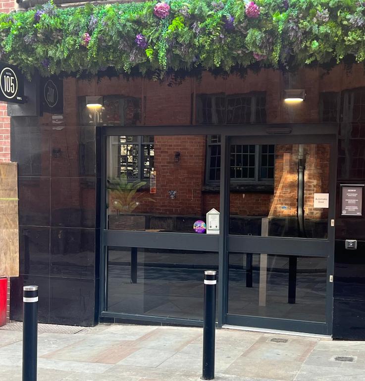 a store front with a glass door with plants on it at Hotel 105 in Liverpool
