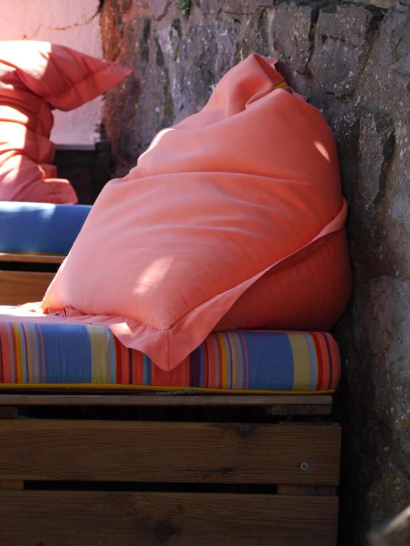 a red pillow sitting on top of a mattress at Hostel & Surfcamp 55 in Ericeira
