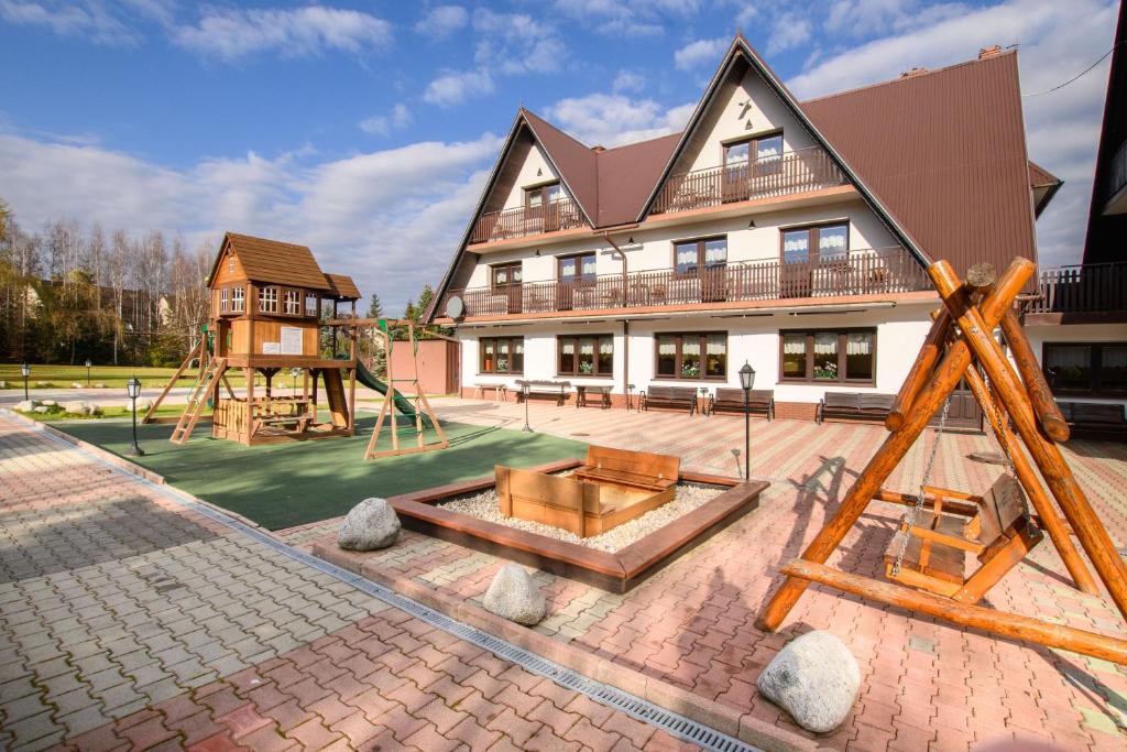 a large building with a playground in front of it at Willa Kubik in Zakopane