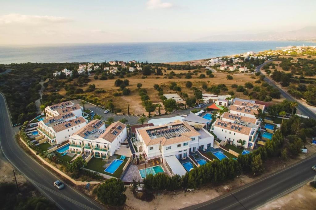 una vista aérea de un complejo con el océano en Latchi Escape Hotel and Suites - By IMH Travel & Tours, en Neo Chorio
