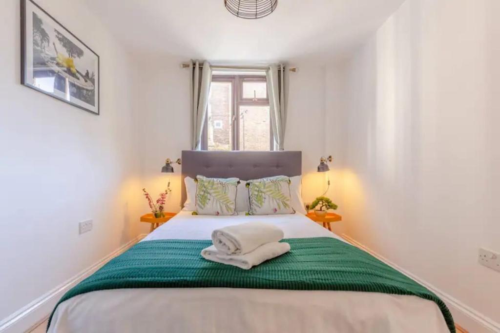 1 dormitorio con 1 cama con 2 toallas en Bright 2 Bedroom House in Kennington en Londres