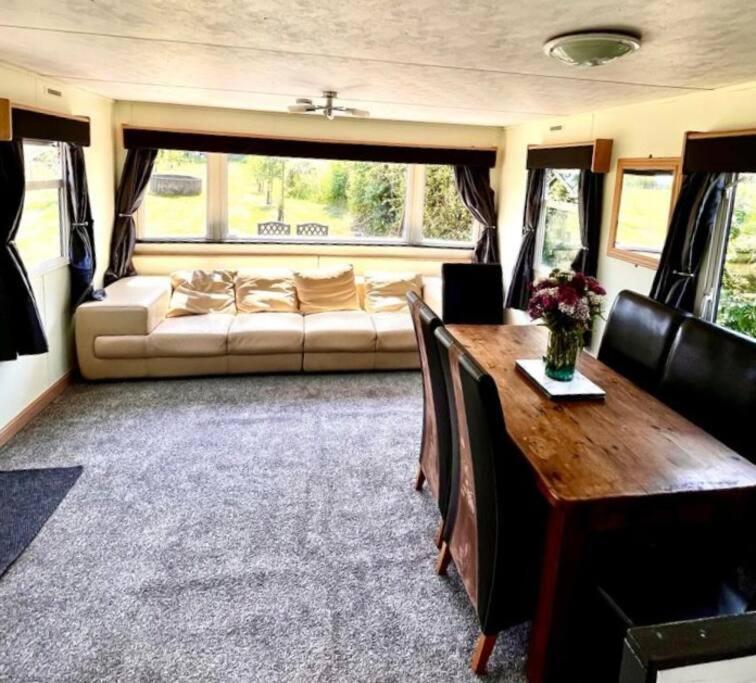 uma sala de estar com um sofá e uma mesa em Woodland Forge Lodge 