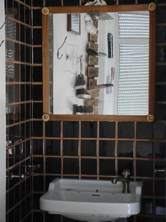 a bathroom with a sink and a mirror at Hostel & Surfcamp 55 in Ericeira